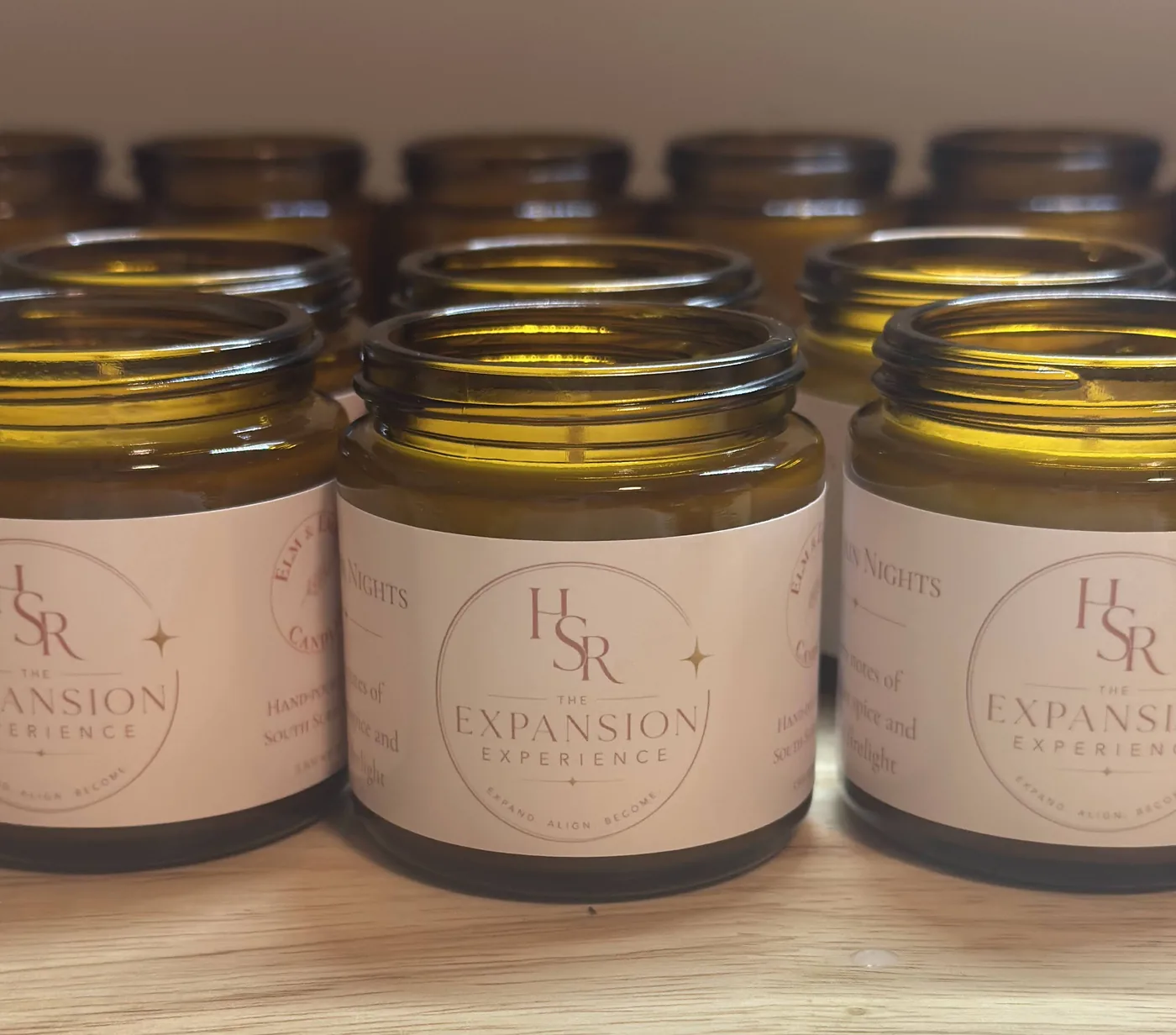 Rows of amber jars with blush custom labels bearing the client’s logo